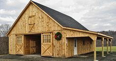 a large wooden barn with a wreath on the door