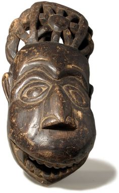 a wooden mask with an intricate design on it's face and head is shown against a white background