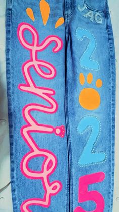 a pair of jeans with the word love on them and an embellishment painted on it