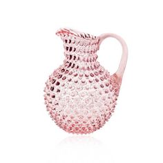 a pink glass pitcher sitting on top of a white table