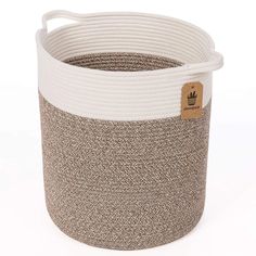 a white and grey basket with a brown tag on it's side, sitting in front of a white background