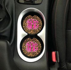 two car cup holders with monogrammed leopard print and pink letters on the center console