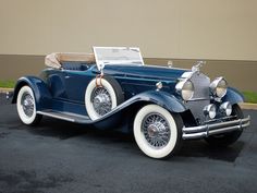 an antique blue car parked in front of a building