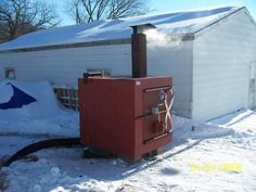 a fire hydrant in the snow next to a building with a roof covered in snow