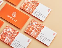 orange and white business cards sitting on top of an orange surface with the word jodo written in chinese