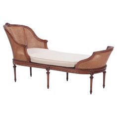 a wicker chaise lounger with cushion on it's back and legs