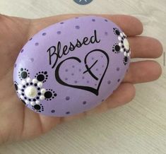 a hand holding a painted rock that says, blessed and decorated with flowers