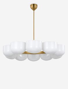 a large chandelier with white glass shades on the bottom and gold trimmings