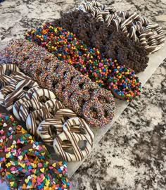 there are many different kinds of donuts on the counter top with sprinkles