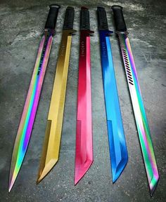 five different colored knives sitting next to each other on top of a cement floor,