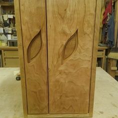 two wooden doors sitting next to each other on top of a workbench in a shop