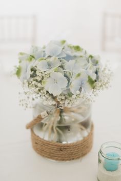 there is a vase with flowers in it and a candle on the table next to it