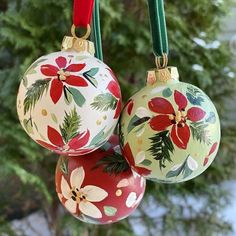 three christmas ornaments hanging from a red ribbon