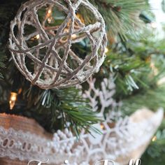 a christmas ornament hanging from a tree with snowflakes and lights in the background