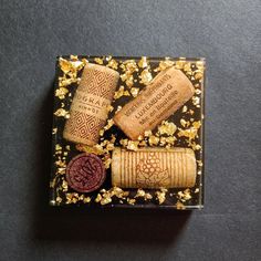 three wine corks sitting on top of a glass plate covered in gold flakes