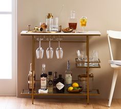 a bar cart with wine glasses and liquor bottles