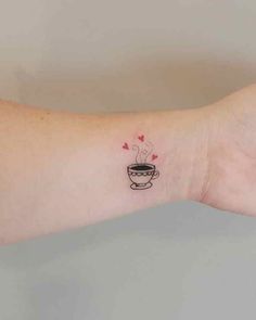 a woman's arm with a small tattoo of a cup of coffee on it