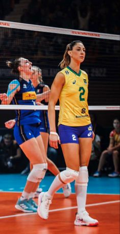 two female volleyball players are playing volley ball