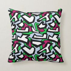 a colorful pillow with black, pink, green and blue graffiti design on it's side