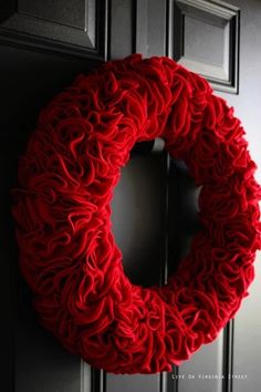 a red wreath is hanging on the front door