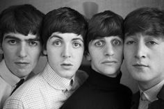 the beatles posing for a black and white photo in front of a wall with their eyes wide open