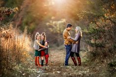 a group of people standing in the middle of a dirt road surrounded by tall grass