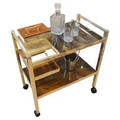 a metal and wood serving cart with two glasses on the top, an ice bucket in the bottom