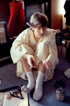 a young boy sitting on the floor next to some scissors and other things in front of him