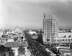 an old black and white photo of a cityscape with tall buildings in the background