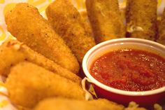 some fried food is sitting on a plate with ketchup and sauce in it