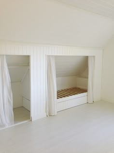 an empty room with white walls and wooden floors