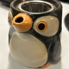 a black and white owl mug with orange eyes