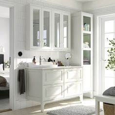 a white bathroom with double sinks and mirrors