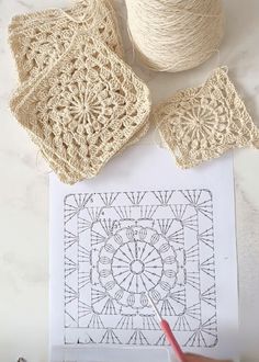 crocheted doily and yarn on top of a white table with scissors next to it