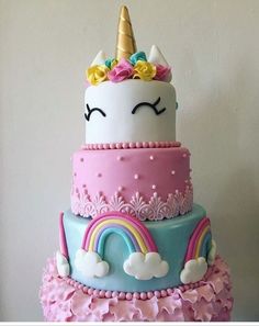 a three tiered cake with a unicorn face on top