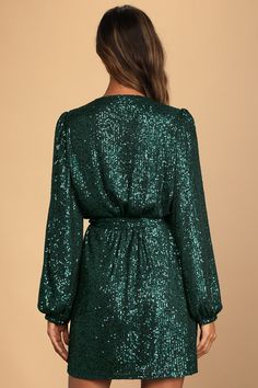 Light up the room with your magnificent self in the Lulus Sparkly Darling Emerald Green Sequin Long Sleeve Wrap Dress! Sparkly green sequins (atop gauzy woven fabric) dazzle across a wrapping bodice (that secures with a hidden snap and two internal ties) and long sleeves with gathered shoulders and elastic cuffs. Matching sash belt cinches the waist above a wrap mini skirt. Fit: This garment fits true to size. Length: Mid-thigh. Size medium measures 35" from shoulder to hem. Bust: Great for any Green Sequin Dress For Date Night, Green Sequined Dress For Fall, Green Sequin Dress For Night Out Party, Green Sequin Dress For Holiday Party, Embellished Green Dresses For Fall, Embellished Green Dress For Fall, Fall Green Embellished Dresses, Green Sequin Cocktail Dress For Holidays, Green Sequin Dress For Holiday Night Out