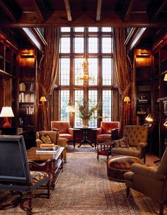 a living room filled with lots of furniture next to a tall bookcase full of books