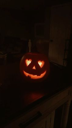 a pumpkin carved to look like a jack o lantern in the dark with its eyes glowing