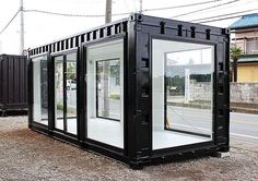 a black and white container sitting on the side of a road next to a building