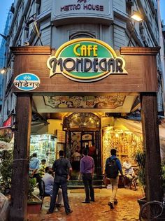 people are standing outside the entrance to a cafe