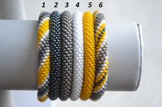 the bracelets are all different colors and have black, white, yellow, and grey beads