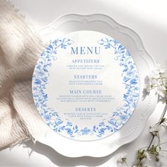 a blue and white plate with the word menu written on it next to some flowers