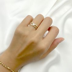 a woman's hand wearing a gold chain bracelet with a diamond ring on it