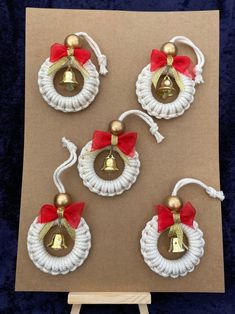 three christmas bells with red bows on them