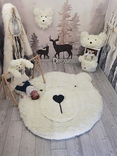 a baby is laying on the floor in front of a wall with deer decals