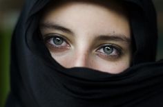 a woman with blue eyes wearing a black scarf