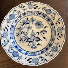 a blue and white plate sitting on top of a wooden table next to a wall