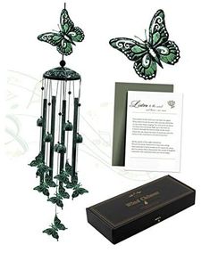 a wind chime with green butterflies on it next to an open box and greeting card