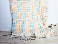 a crocheted blanket sitting on top of a wooden table