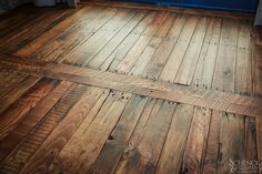 an old wooden floor in a kitchen with blue walls